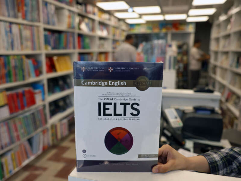 A bookstore employee displays an International English Language Testing System (IELTS) book in Tehran, Iran, on September 7, 2026. Testing has been suspended in Iran since September 1 following the latest U.S. sanctions.