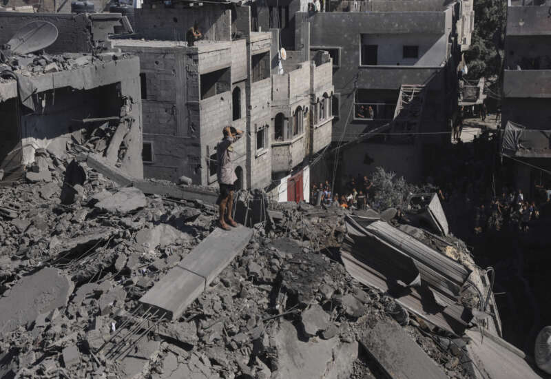 Residents move through rubble between damaged residential buildings after an Israeli airstrike in the Abu Dalal area of Nuseirat refugee camp, central Gaza Strip, on September 9, 2026.