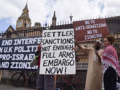 Protesters hold placards stating 'Settler sanctions not enough, full arms embargo now' and 'No to anti-semitism, no to Zionism' during a demonstration in Parliament Square on September 9, 2026, in London, UK.