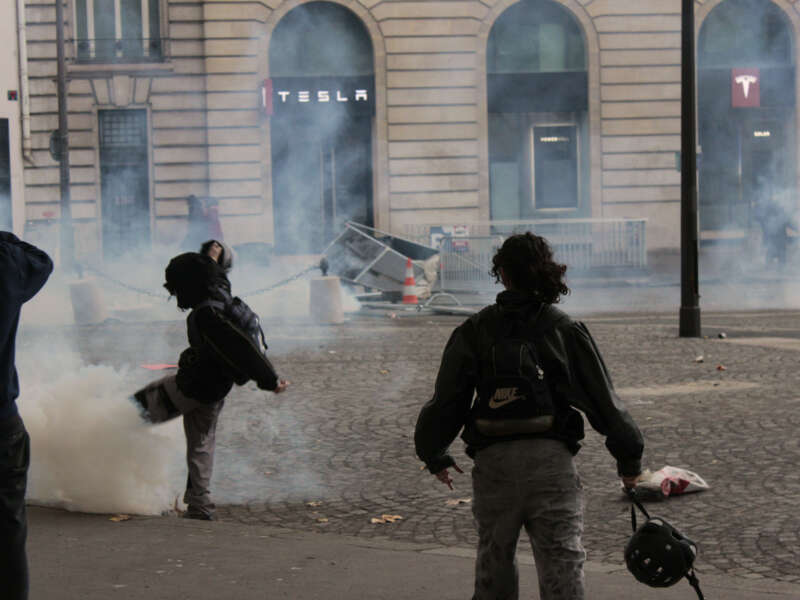 A demonstrator kicks a tear gas canister away during student and cost-of-living protests in Paris, France, on October 17, 2026.