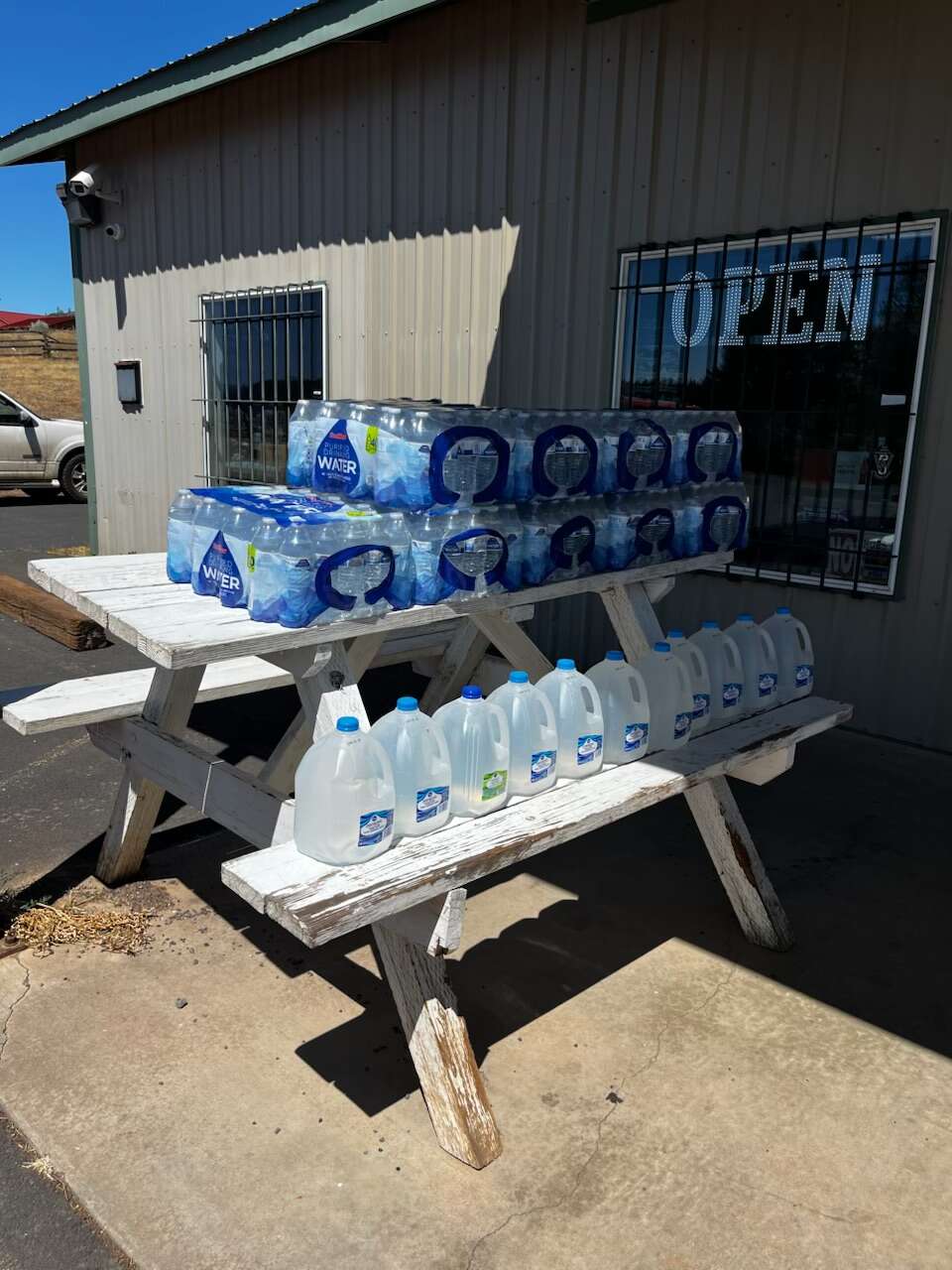 Multiple cases of water are stacked for a supply drop in Warm Springs.