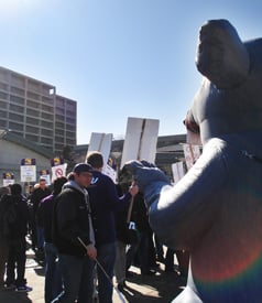 A giant inflatable rat, brought to symbolize the administration, watches over the protest.