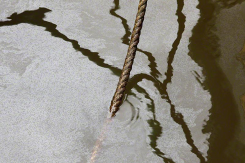 Oiled mooring rope and oil sheen on water's surface inside Christian Harbor, Mississippi, August 13, 2010.