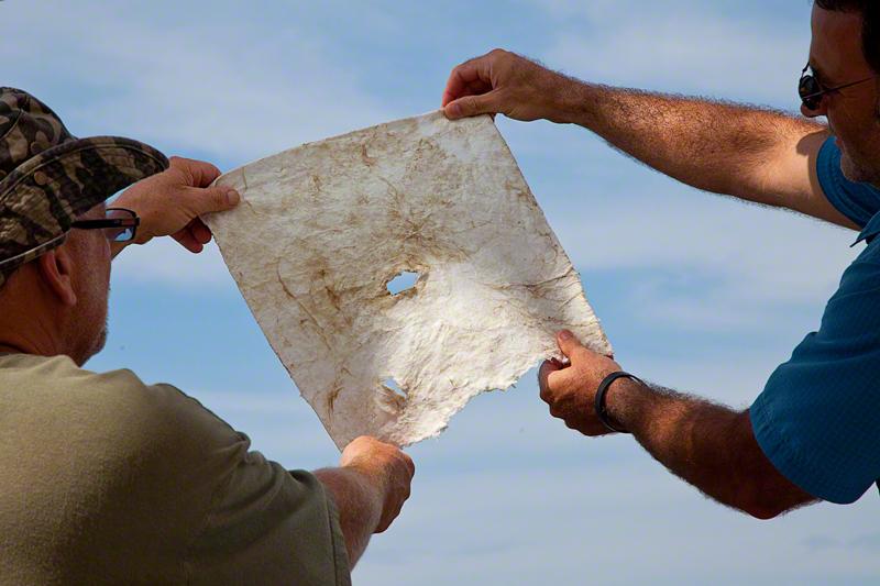 Miller and Dahr Jamail holding oil-soaked sorbent pad.