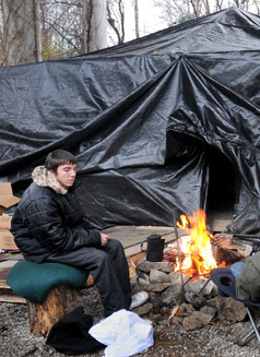 A teenage boy sits outside a communal structure in Tent City. The numbers of homeless teenagers is growing rapidly in the United States. Photo: John Mottern