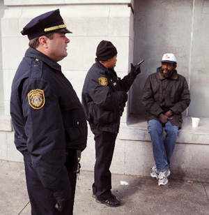 Lt. Sandra Marshall, center of the Memphis Police Department talks to Robert Warren, seated, a homeless man in Memphis, Tennessee as Lt Felix Calvi looks on during the first day of a citywide sweep of the homeless population in the city in December 2009. Photo: John Mottern
