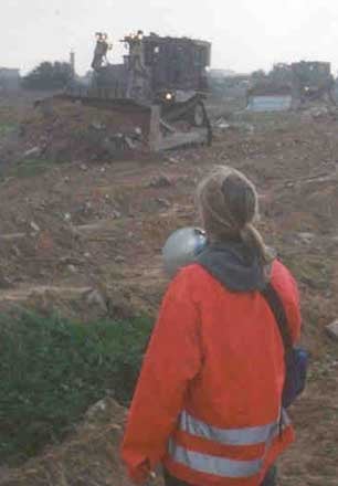 Rachel Corrie nonviolently blocks Israeli bulldozers from destroying Palestinian homes along the Rafah/Egyptian border along with nine other International Solidarity Movement volunteers, March 16, 2003. Photo was taken earlier in the day Corrie was run over and killed by a bulldozer.