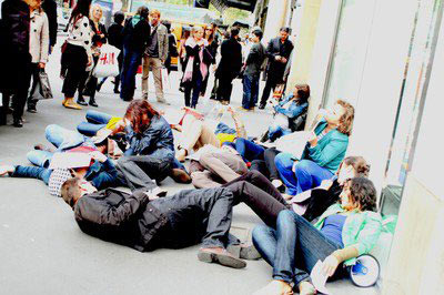 Activists in Paris with the Clean Clothes Campaign draw attention to mass fainting incidents in Cambodian garment manufacturing plants. (Photo: Clean Clothes Campaign)