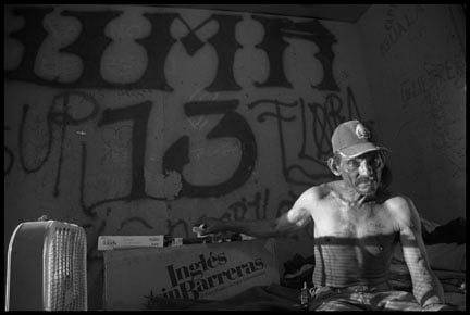 Aristeo Luna sleeps beneath bare plywood walls covered in graffiti, like the 13 that is the symbol of a gang based in Los Angeles.