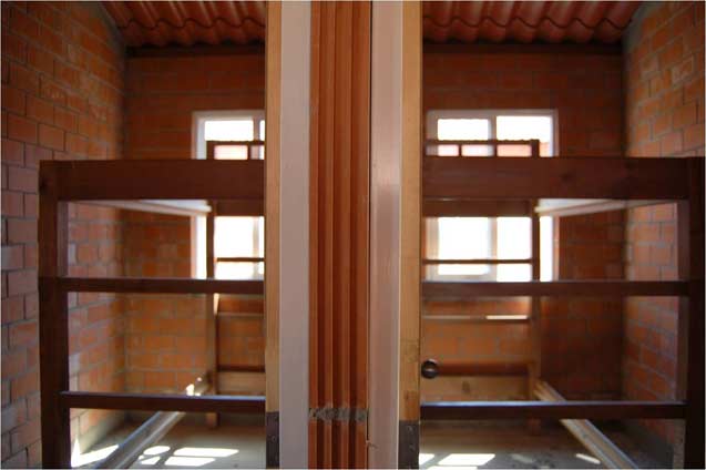 The two children’s rooms within any given house in the SRC. Not yet fully furnished, a tiny desk and bureau is still to be placed in each. The dividing wall reaches only a foot or two higher than the top bunk, leaving a large space within the gabled roof. (Photo: Jennifer Coute-Marotta)