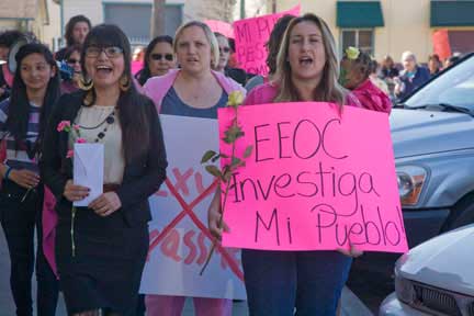 Laura Robledo, letter in hand, leads marchers through the parking lot. (Photo: David Bacon)