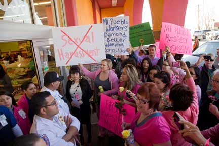 The demonstrators make their demand heard by chanting outside the store. (Photo: David Bacon)