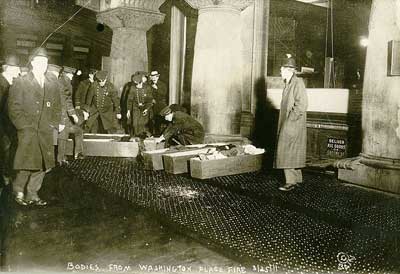 Photograph shows police or fire officials placing Triangle Shirtwaist Company fire victims in coffins. 