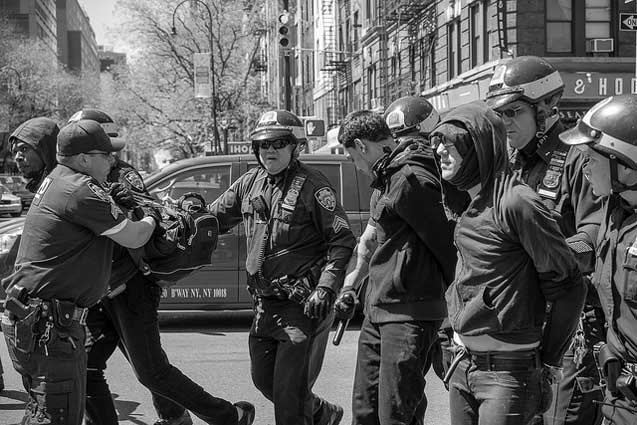 Police lead several more arrestees into custody during the anticapitalist march. (Photo: Craig O'Connor)