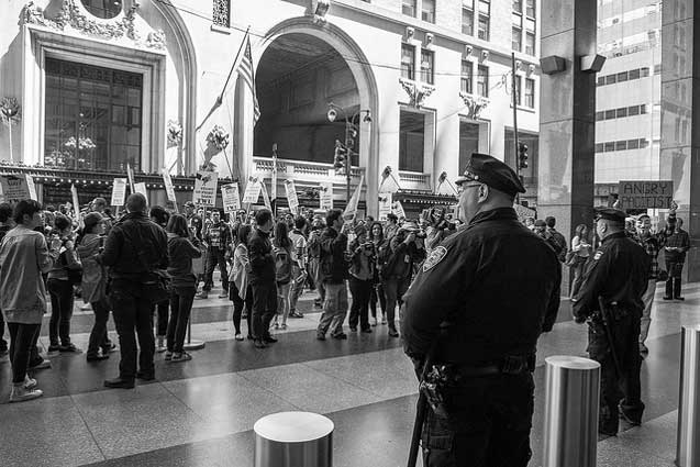 NYPD officers guard the doors as protesters gather outside. (Photo: Craig O'Connor)