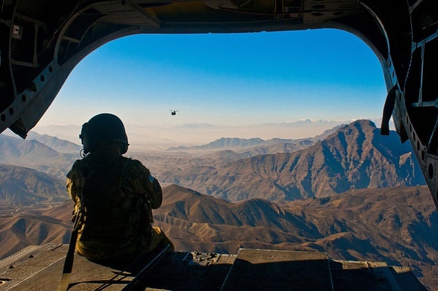 U.S. Army Spc. Devon Boxa, 7-158th Aviation Regiment, admires the Afghanistan landscape out the back door of her CH-47D Chinook helicopter as another Chinook follows. The choppers were flying from Kabul to Jalalabad Dec. 17, 2010. U.S. Army photo by Spc. Ken Scar, 7th MPAD. (Photo: <a href=