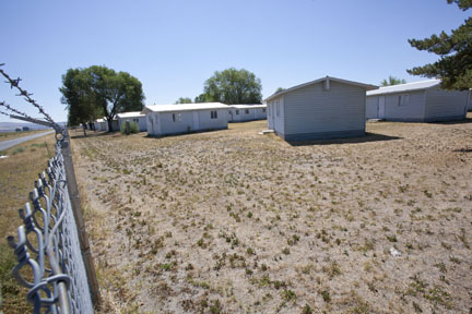 Behind the barbed-wire fence - the vacant cabins of the Newell Migrant Center. (Photo: David Bacon).