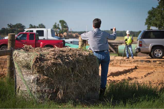 Julia Trigg Crawford on her land taking pictures of the pipeline installation while a TransCanda employee films her. (Photo: ©Julie Dermansky)