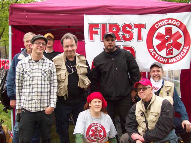 May 1, 2012: Danny Edwards - posing with fellow Chicago Action Medical volunteers at their health care booth in Union Park, where street medics were volunteering to provide first aid and emergency health care for participants at the annual May Day rally and march. Danny - the only medic not smiling - is standing in front of the CAM banner.