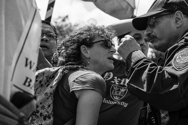 A woman confronts police from the Department of Homeland Security outside the Justice Department.