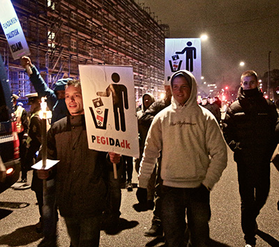 Nicolai Sennels (left, holding PEGIDAdk sign and a torch) led the PEGIDA march to the Little Mermaid statue, a symbol of Danish national identity. (Photo: Linda Pershing)