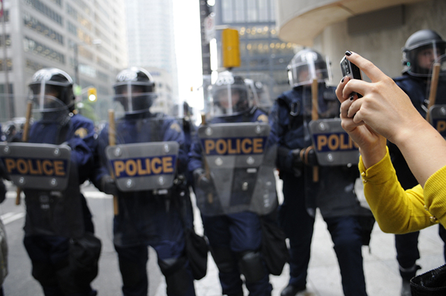 Making laws to forbid or even impede on this right does the people of the United States a disservice, which is why federal courts have upheld the act as something protected by the First Amendment. (Photo: Woman takes photos of Toronto Police during protest of 2010 G20 summit- Shutterstock)