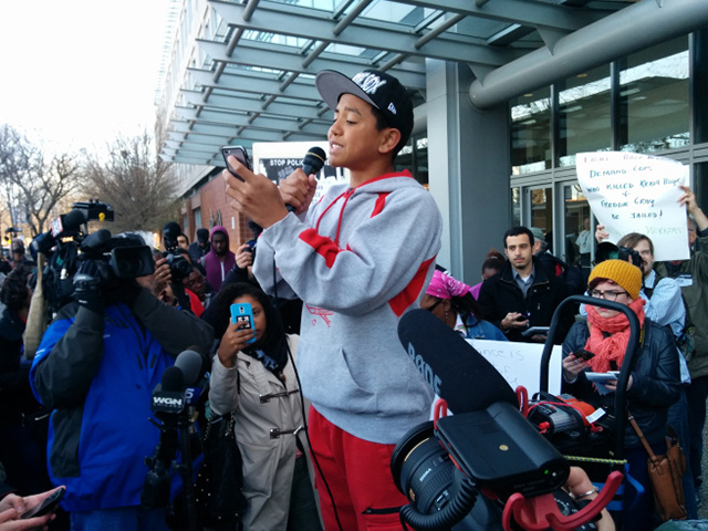 A 14 year old poet named Jalen performs outside police headquarters before a crowd of hundreds. (Photo: Kelly Hayes)