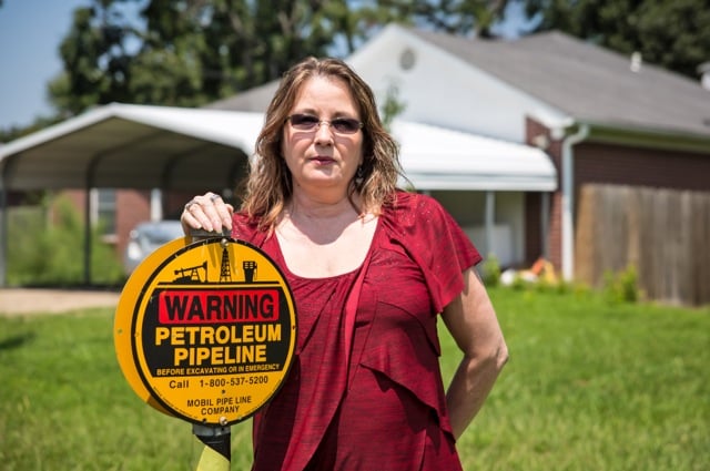 Ann Jarrell in front of her home in Mayflower, Arkansas. The pipeline warning sign was put in after the spill. (Photo: Julie Dermansky)