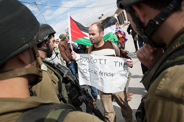 A Palestinian activist with a sign reading, 