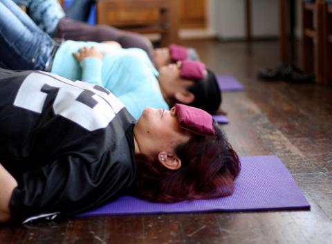 MUA offers wellness and self-care for its members. Here, members participate in a weekly yoga class offered by a volunteer at the group’s Fruitvale office. (Photo: Rucha Chitnis)