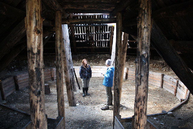 Freda Huson stands with reporter Tony Manno in the unfinished pit house, a traditional structure that will one day become her home. (Photo: Courtesy of Tony Manno)