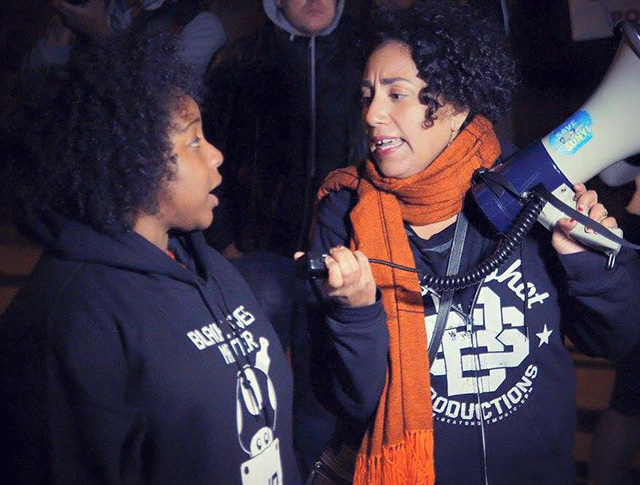 Taina Asili singing with Capital Area Against Mass Incarceration member Clyanna Lightborn at a protest in response to the police killing of Dontay Ivy. (Photo: Masai Atg)