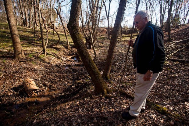 Ron Thomas and his wife, Joann, worry about the stream of water running in a wooded gully on their property, which abuts one of the coal ash pits. (Credit: Sara Peach)