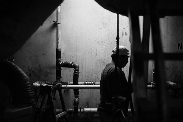 The captain of the J.D. walks around the engine room of his ship. (Photo: Michael Stein)