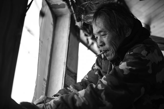 The deckhand of the J.D. shrimping boat repairs the ship's windows. (Photo: Michael Stein)