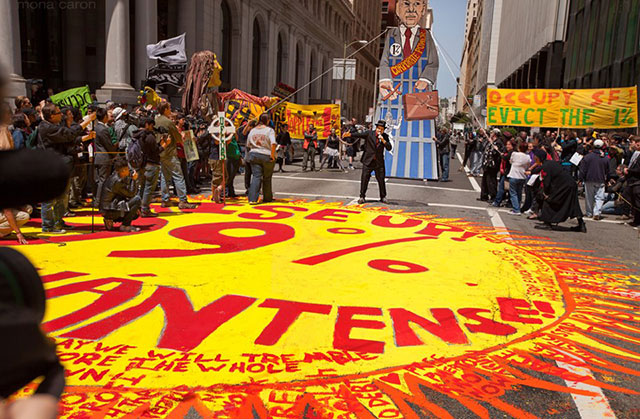 Bogad as the 1% at a theatrical protest in San Francisco, where all the protesters painted the stage on the street and performed on it together, 2012. (Credit: Mona Caron)