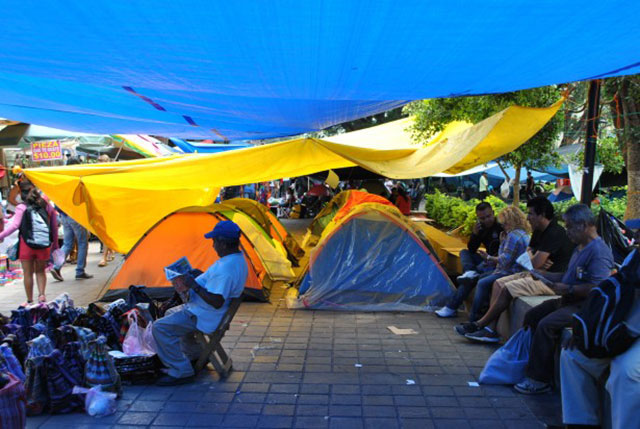 Teachers and souvenir sellers share the space below the canopies in the occupied main square of Oaxaca city. (WNV / Shirin Hess)