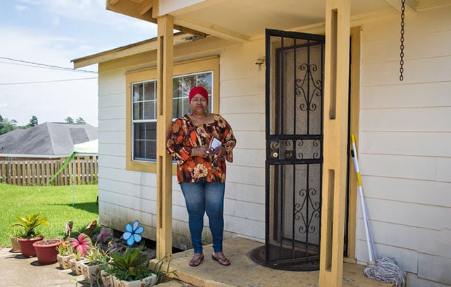 Cynthia Johnson, shown outside of her home, seldom does anything in her yard due to the noxious smell often in the air. (Photo: Julie Dermansky)