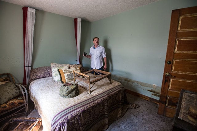 Frank Bonifay checks out the damage in his flooded house. (Photo: Julie Dermansky)