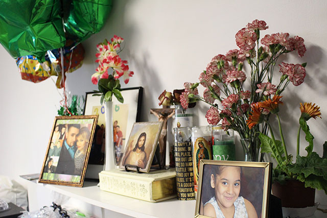 Photographs, flowers, and religious icons decorate the table of the room at University Church where Jose Juan Moreno has been living in 