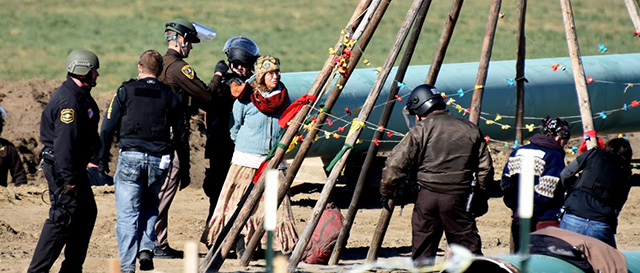 Police handcuff the last two water protectors remaining amid the tipi poles at Standing Rock on October 10, 2016. (Photo: Ellen Davidson)