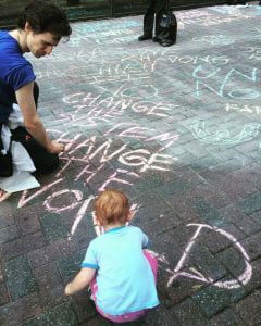 A child helps draw with chalk on the sidewalk during the march in Charlotte on September 24. (WNV / Roan Boucher)