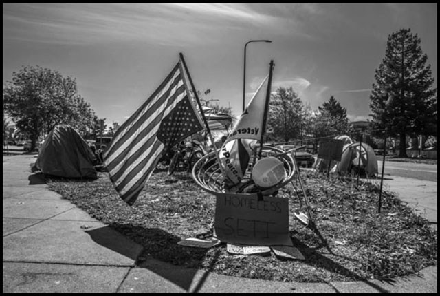 After being forced by police to disband one camp on the grass median in the middle of Adeline Street, homeless community activists set up another across the street. (Photo: David Bacon)