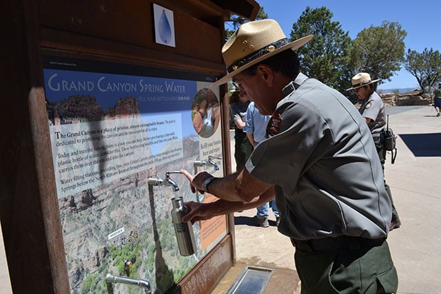 Caption: The Superintendent of Grand Canyon National Park fills up a reusable water bottle at a hydration station. In 2012, Grand Canyon National Park banned the sale of plastic water bottles inside the park. (Photo: Corporate Accountability International)