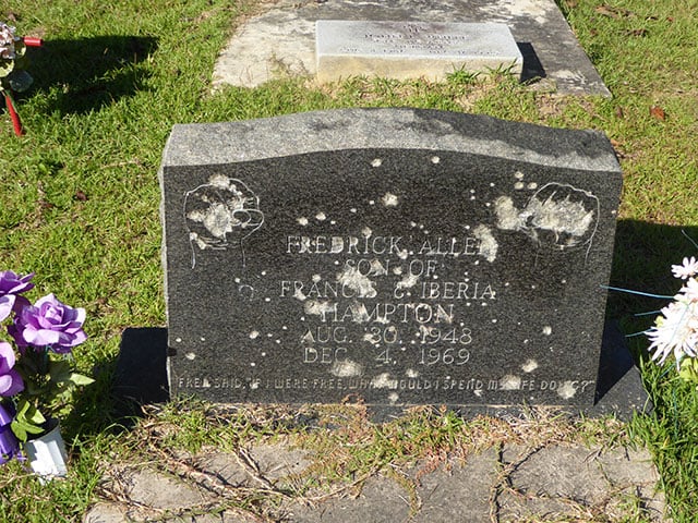 The headstone of slain Black Panther leader Fred Hampton in Haynesville, Louisiana, has been riddled by a barrage of bullets from unidentified night riders. Flint Taylor — one of the lawyers for Hampton's family — recently journeyed to Haynesville to eulogize Fred Hampton’s mother, Iberia, a devoted mother and courageous activist who passed away in October 2016. He discovered this desecration of Hampton's grave at that time. (Credit: Flint Taylor)