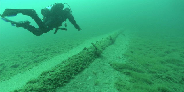 A diver inspects the aging and barnacle-encrusted Enbridge Line 5 oil pipeline that lies under the Straits of Mackinac, which connect Lake Michigan and Lake Huron. (Image: Still from National Wildlife Federation video)