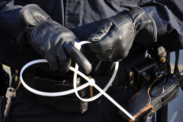 Police hold zip ties for restraining peaceful protesters at an Occupy San Francisco rally in San Francisco, California, December 7, 2011. Over the past few years, ALEC has been pushing state-level legislation aimed at repressing direct action. (Photo: Steve Rhodes)