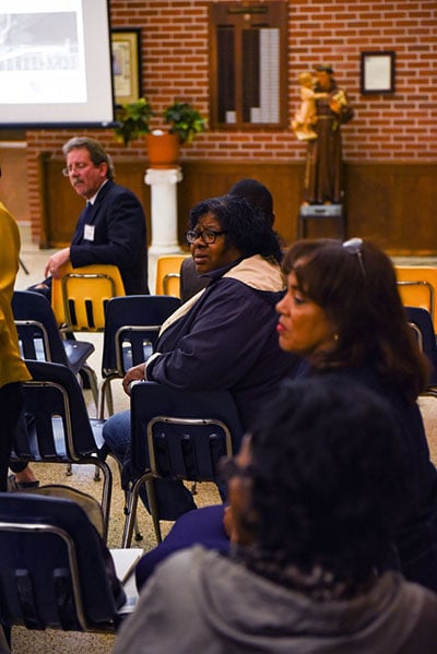 A Ninth Ward resident turns to her friend after the Florida Avenue Roadway proposal is first explained. (Photo: Michael Stein)