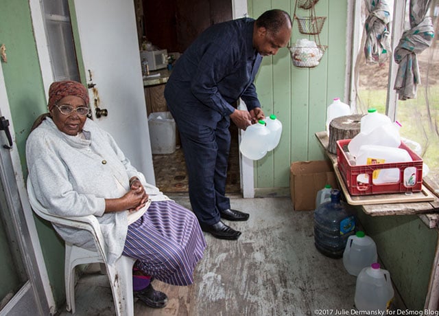 Roy Bowman delivering clean water to Viola Marshall, one of the elders in town he and his wife make sure have water on a regular basis. (Photo: Julie Dermansky) 