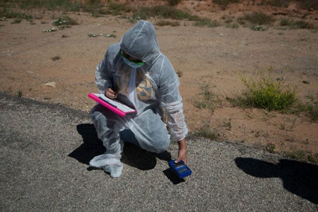 Leona Morgan, representative from “Haul No!” and co-founder of the organization “Dine No Nukes,” takes radioactivity readings around the White Mesa Mill. Last year there was a radioactive spill in this area. (Photo: Garet Bleir)
